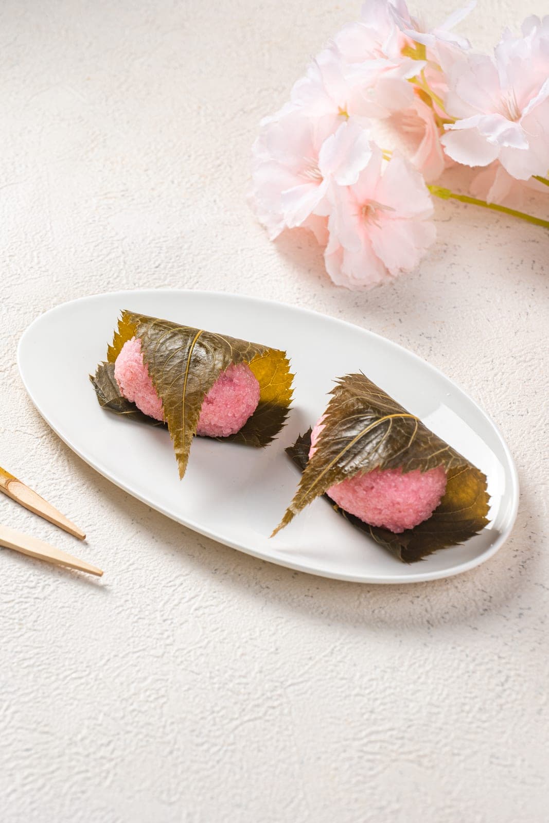 Pink sakura mochi wrapped in a preserved cherry leaf